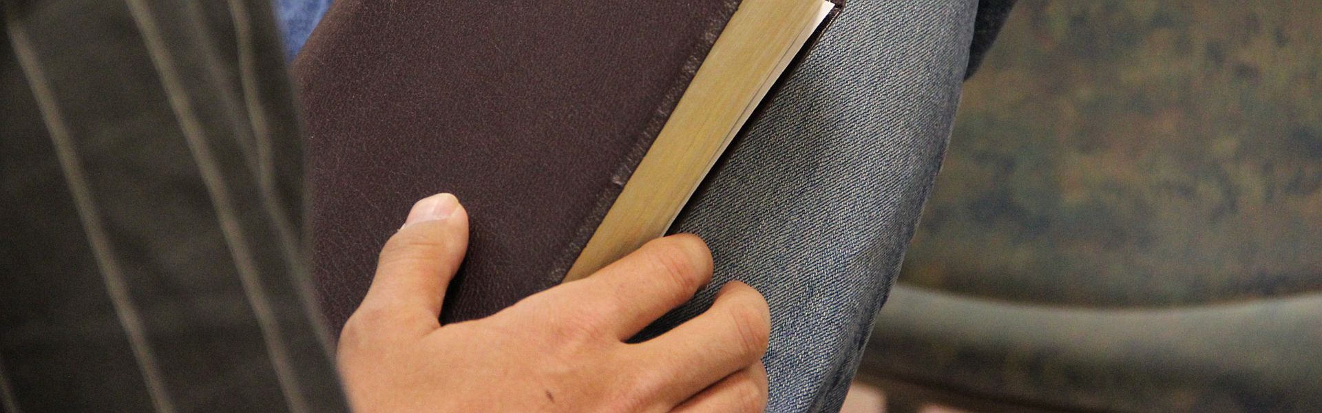 Man met een bijbel op schoot Man met een bijbel op schoot bij de column 'Geloven' van Paul Schrijft